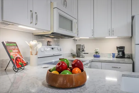 a kitchen with stainless steel appliances granite countertop a sink a stove and cabinets