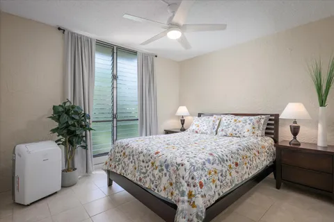 a bedroom with a large bed and a potted plant