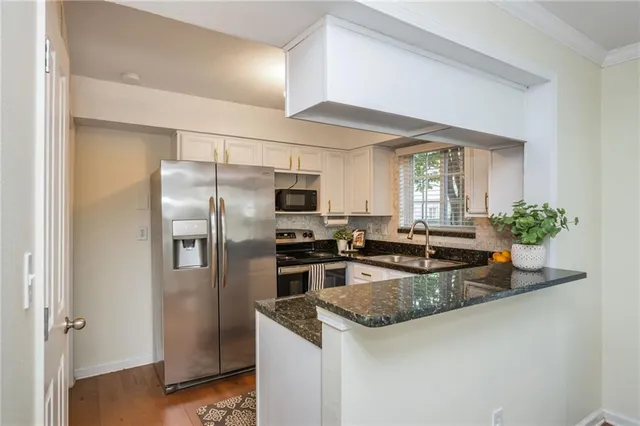 a kitchen with a refrigerator a sink a stove and cabinets