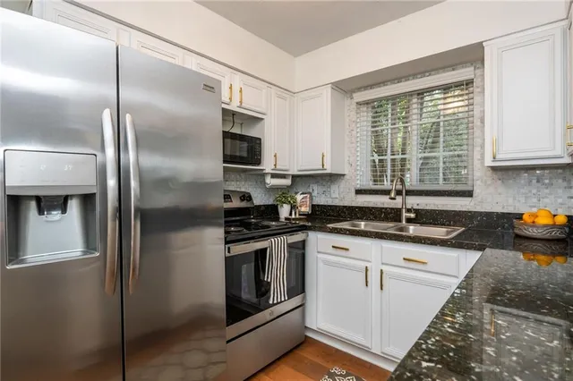 a kitchen with stainless steel appliances granite countertop a sink stove and refrigerator