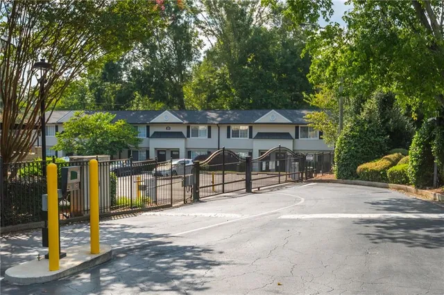 a view of a house with wooden fence next to a road