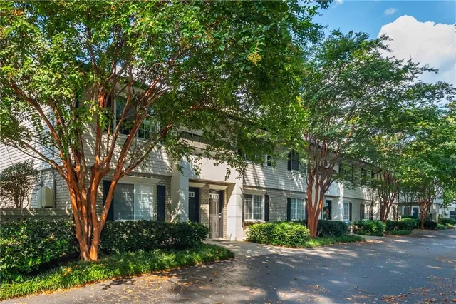 front view of a brick house with a large trees