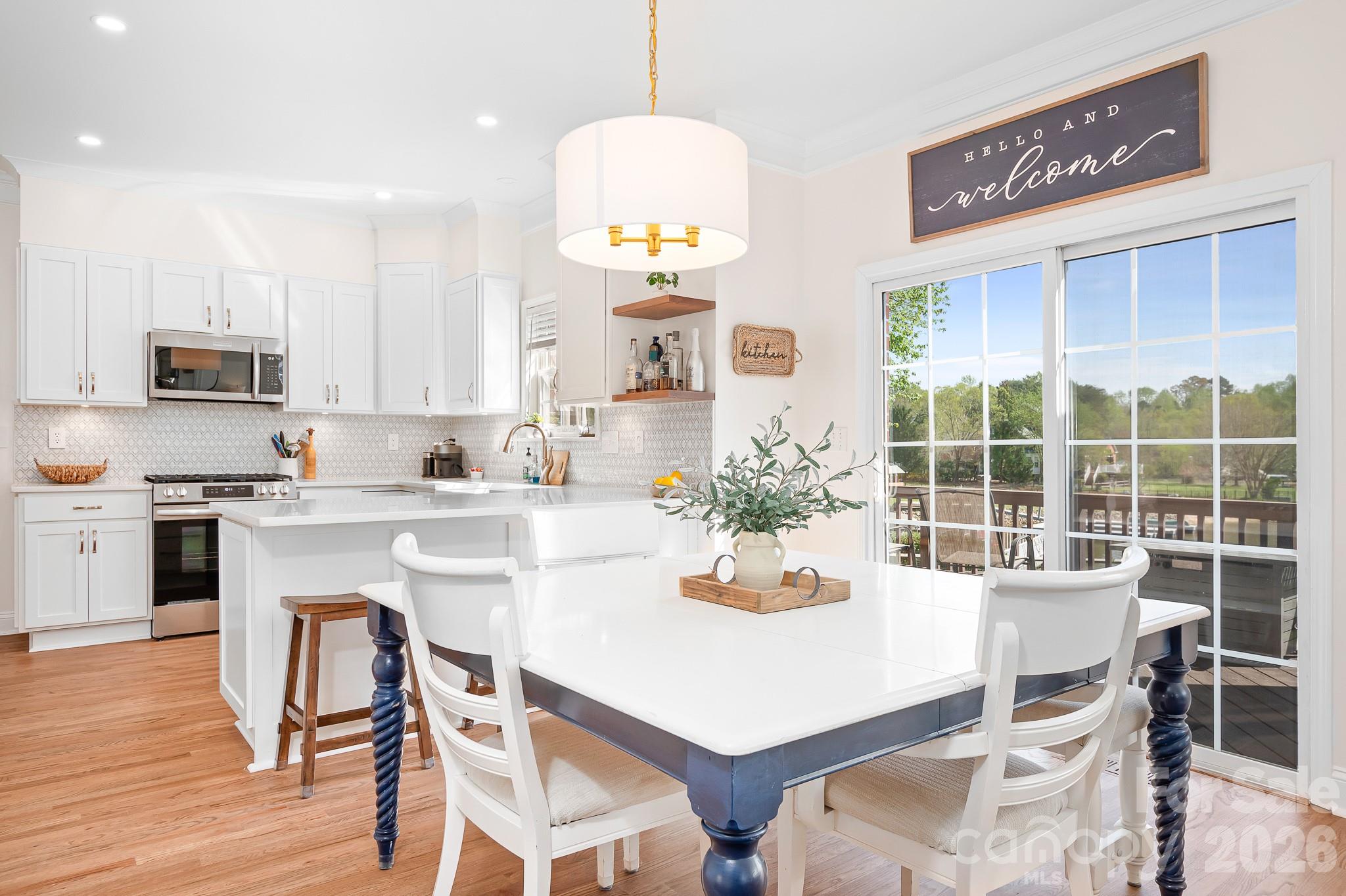 220 Chandeleur Drive Mooresville, NC 28117 - Photo 12 of 38 a kitchen with a dining table chairs and refrigerator