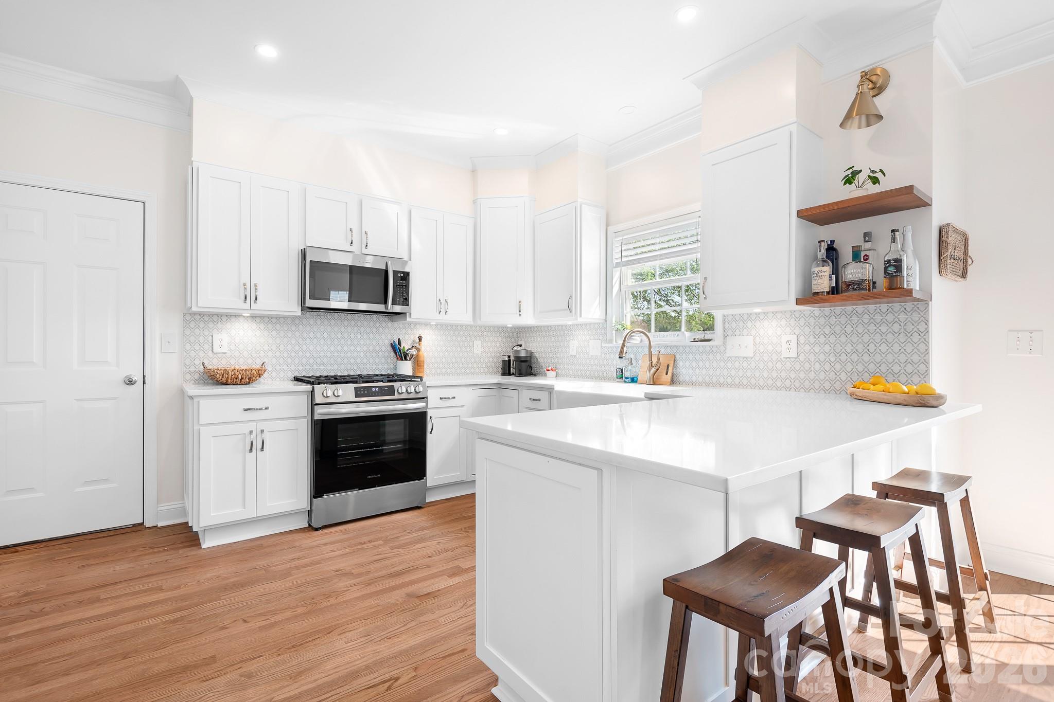 220 Chandeleur Drive Mooresville, NC 28117 - Photo 15 of 38 a kitchen with kitchen island a stove a sink and a refrigerator