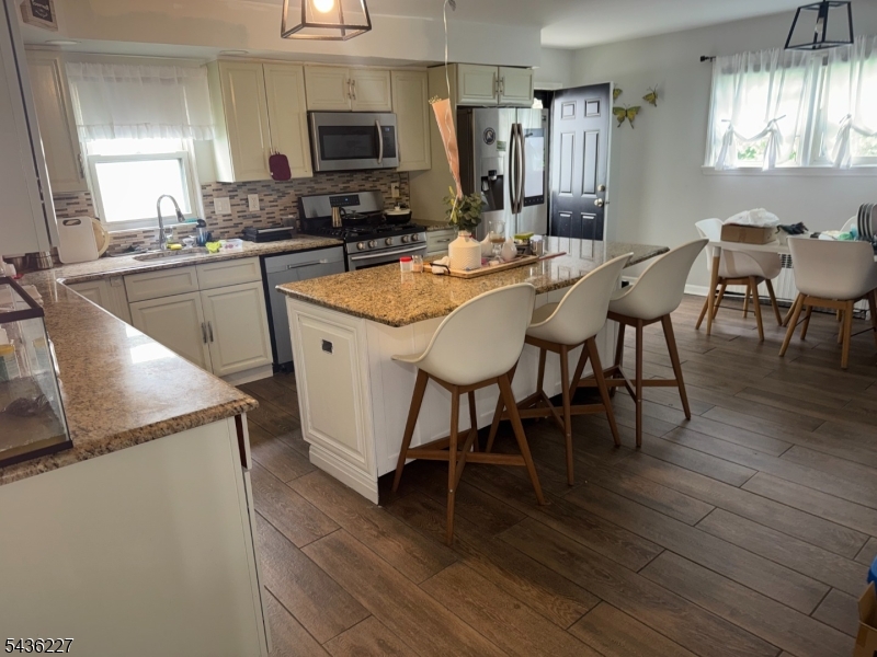 218 Bell Avenue Lodi, NJ 07644 - Photo 6 of 14 a kitchen with stainless steel appliances granite countertop a table chairs sink and cabinets