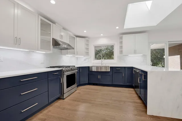 a kitchen with stainless steel appliances granite countertop a stove a sink and a refrigerator