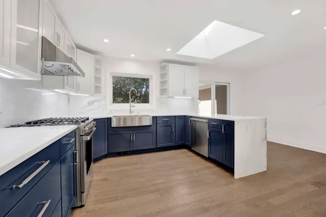 a kitchen with stainless steel appliances granite countertop a stove a sink and a refrigerator