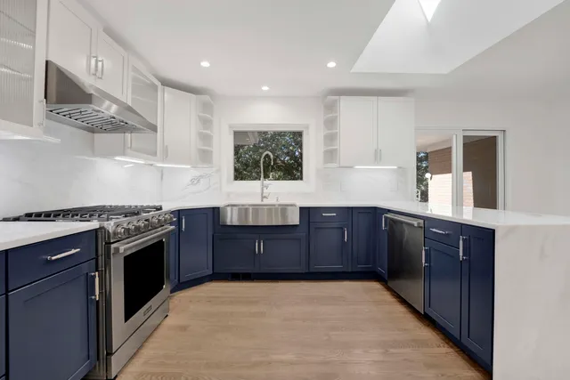 a kitchen with stainless steel appliances granite countertop a stove a sink and a refrigerator