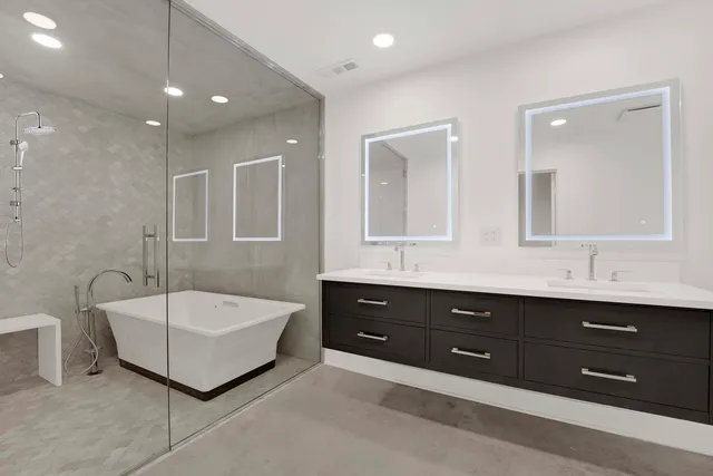 a spacious bathroom with a tub double sink and mirror