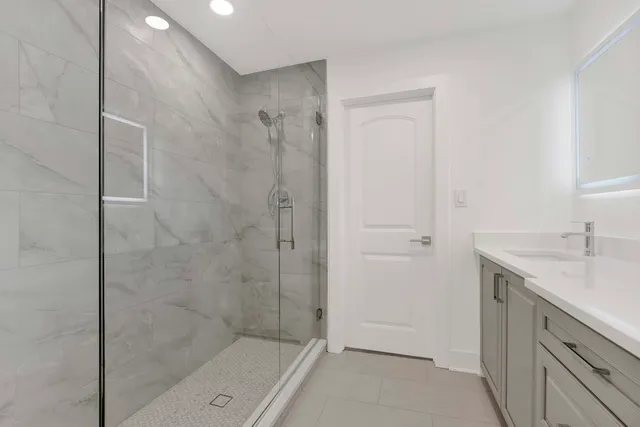 a bathroom with a granite countertop sink a shower and a mirror
