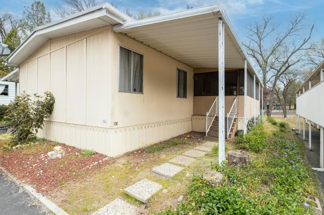 a white house with tree in front of it