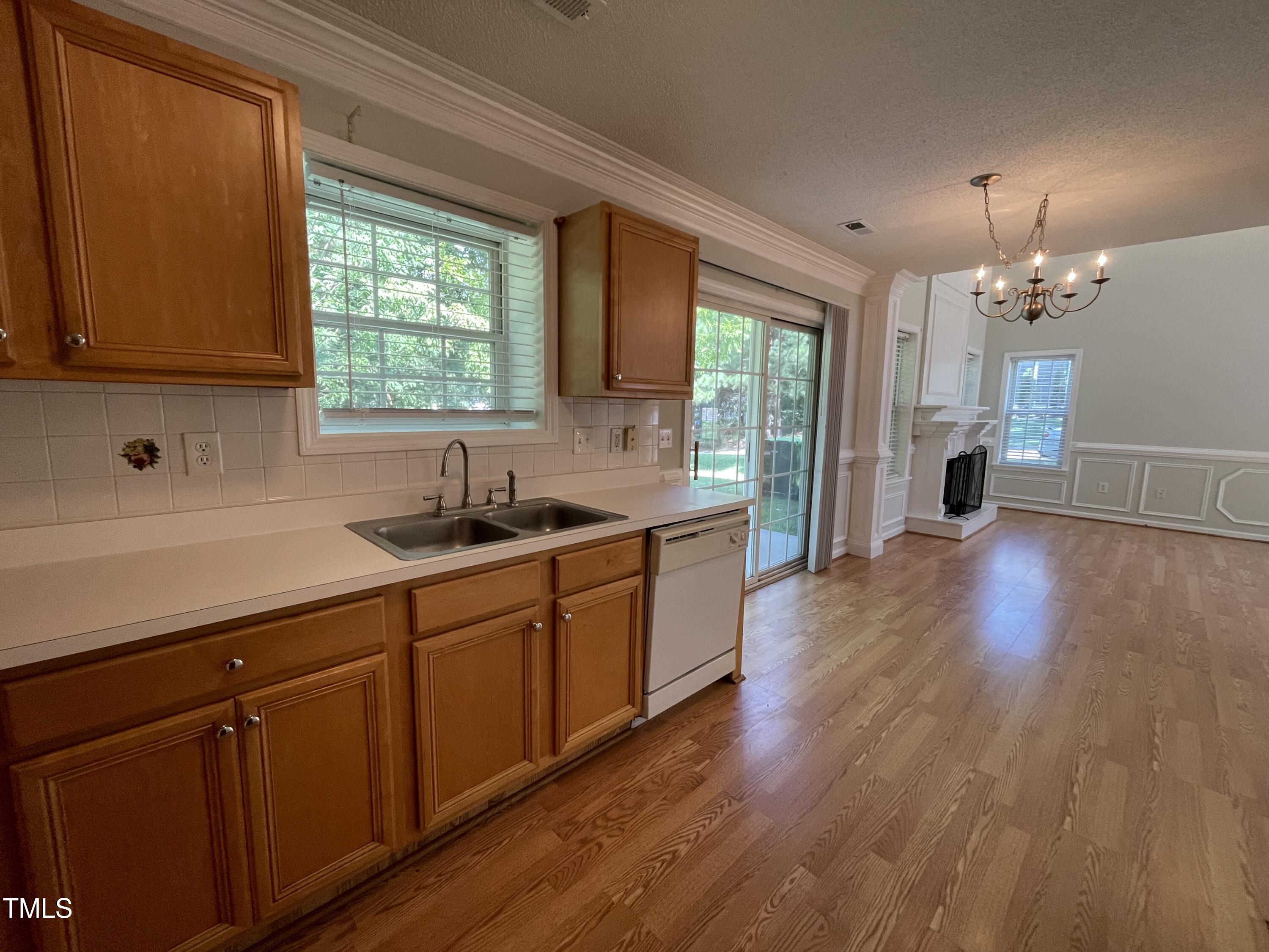 300 Firefly Road Holly Springs, NC 27540 - Photo 12 of 23 a kitchen with stainless steel appliances wooden floors and wooden cabinets