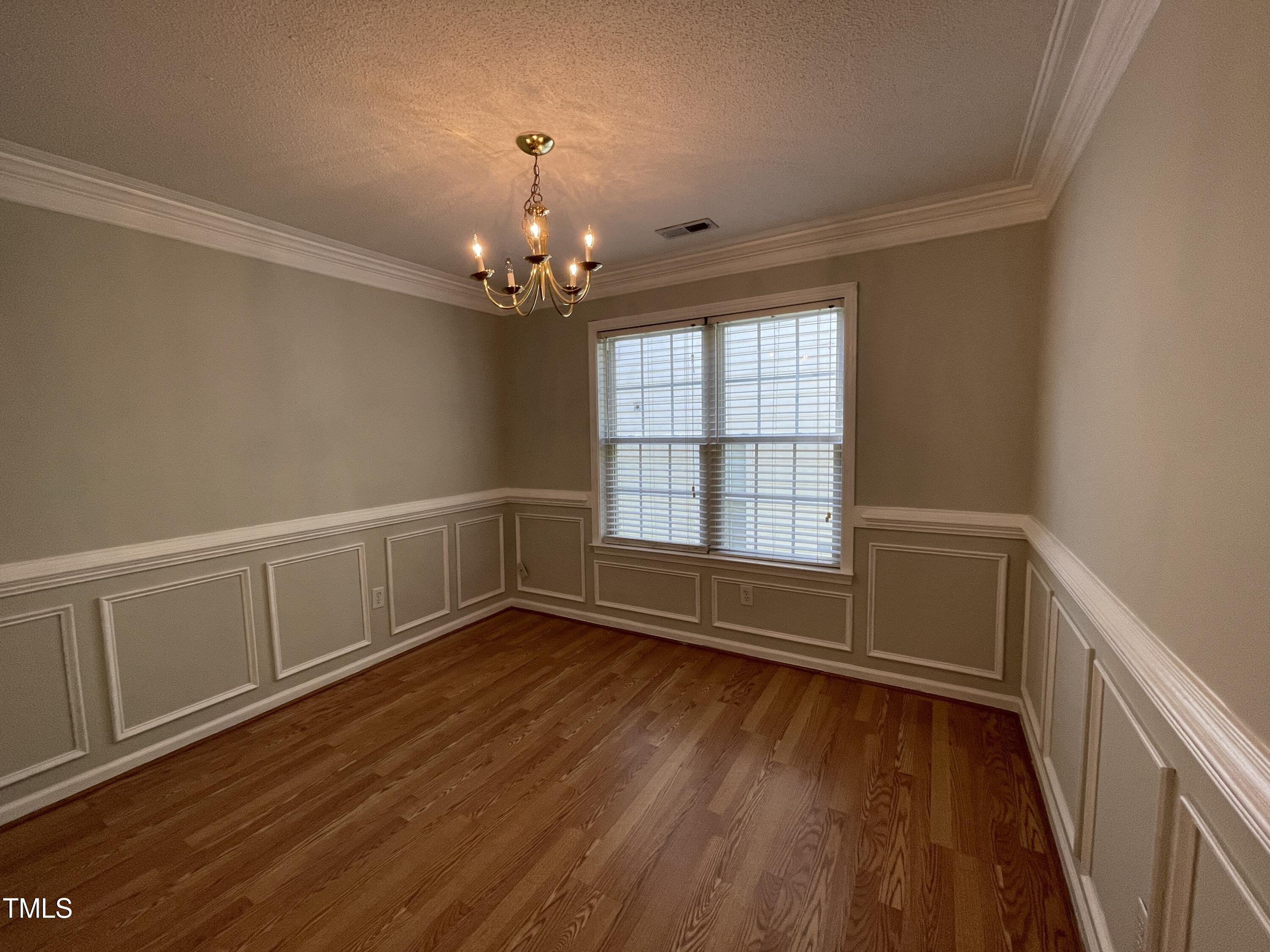 300 Firefly Road Holly Springs, NC 27540 - Photo 13 of 23 a view of an empty room with wooden floor and a window