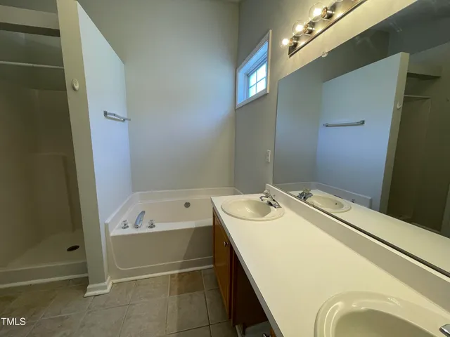 a bathroom with a tub sink and mirror