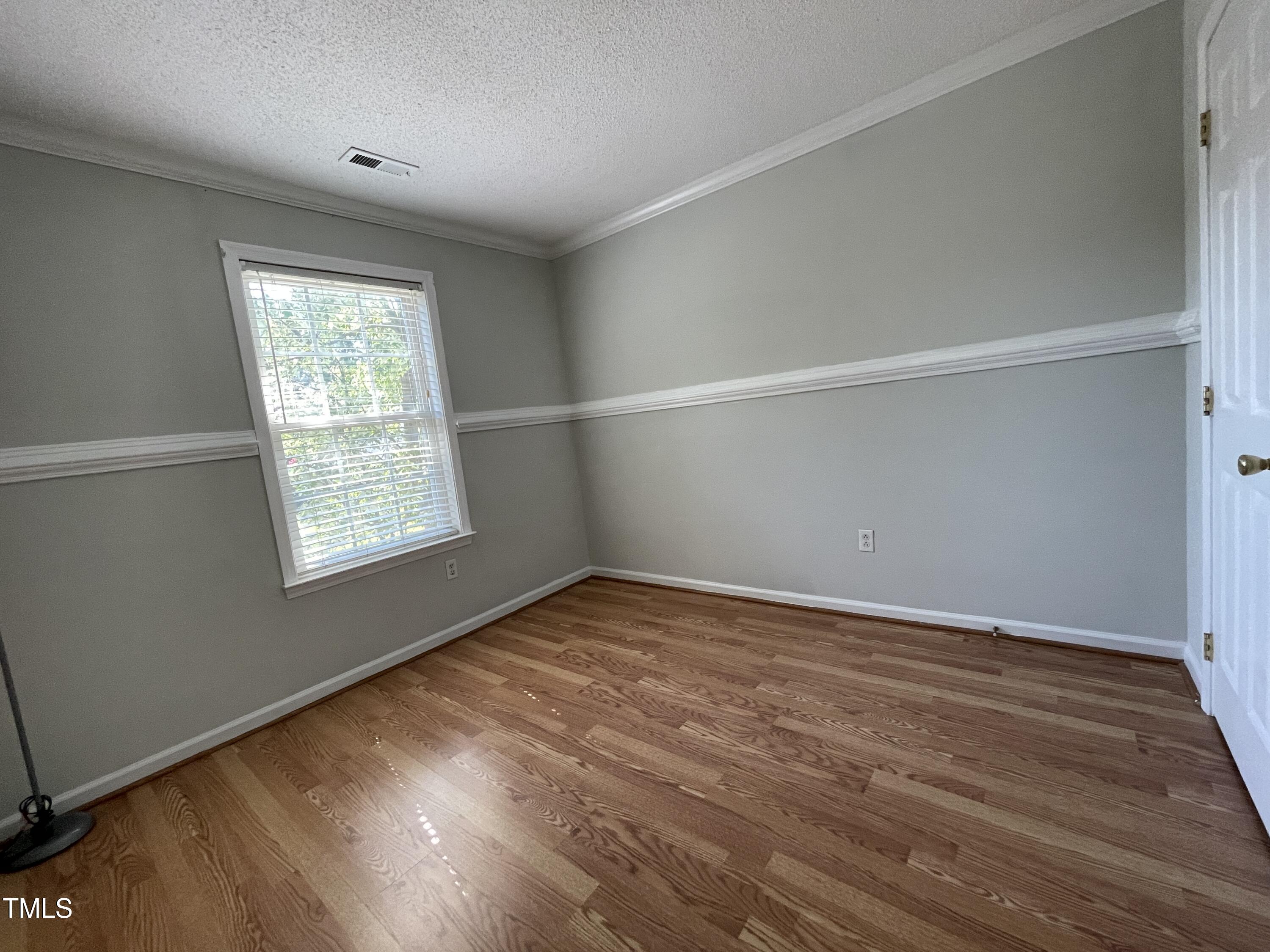 300 Firefly Road Holly Springs, NC 27540 - Photo 19 of 23 an empty room with wooden floor and windows