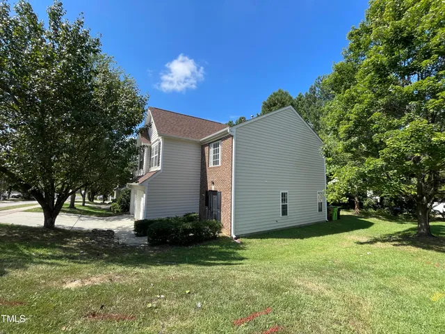 a view of a backyard with potted plants and large trees