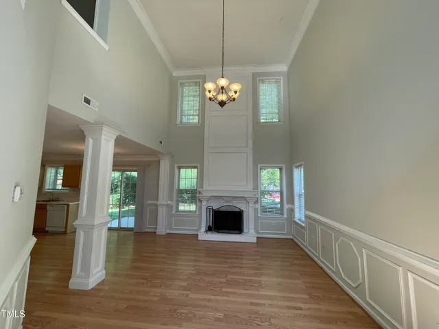 a view of a livingroom with wooden floor and a fireplace