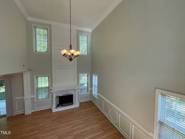 a view of a livingroom with a fireplace wooden floor and a chandelier
