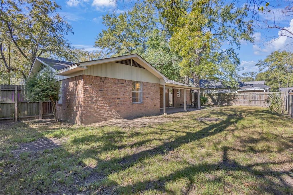 815 North Bledsoe Street Gilmer, TX 75644 - Photo 23 of 25 a view of a yard in front of a house with large tree