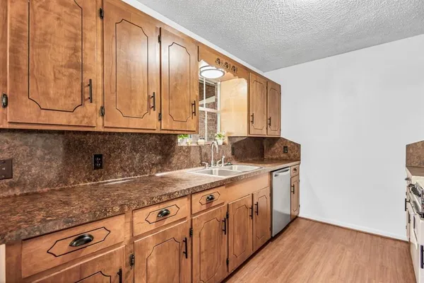 a kitchen with granite countertop a sink a stove and cabinets