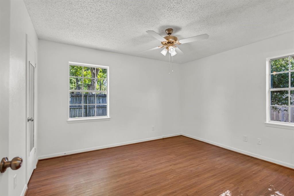 815 North Bledsoe Street Gilmer, TX 75644 - Photo 9 of 25 a view of an empty room with wooden floor and a window
