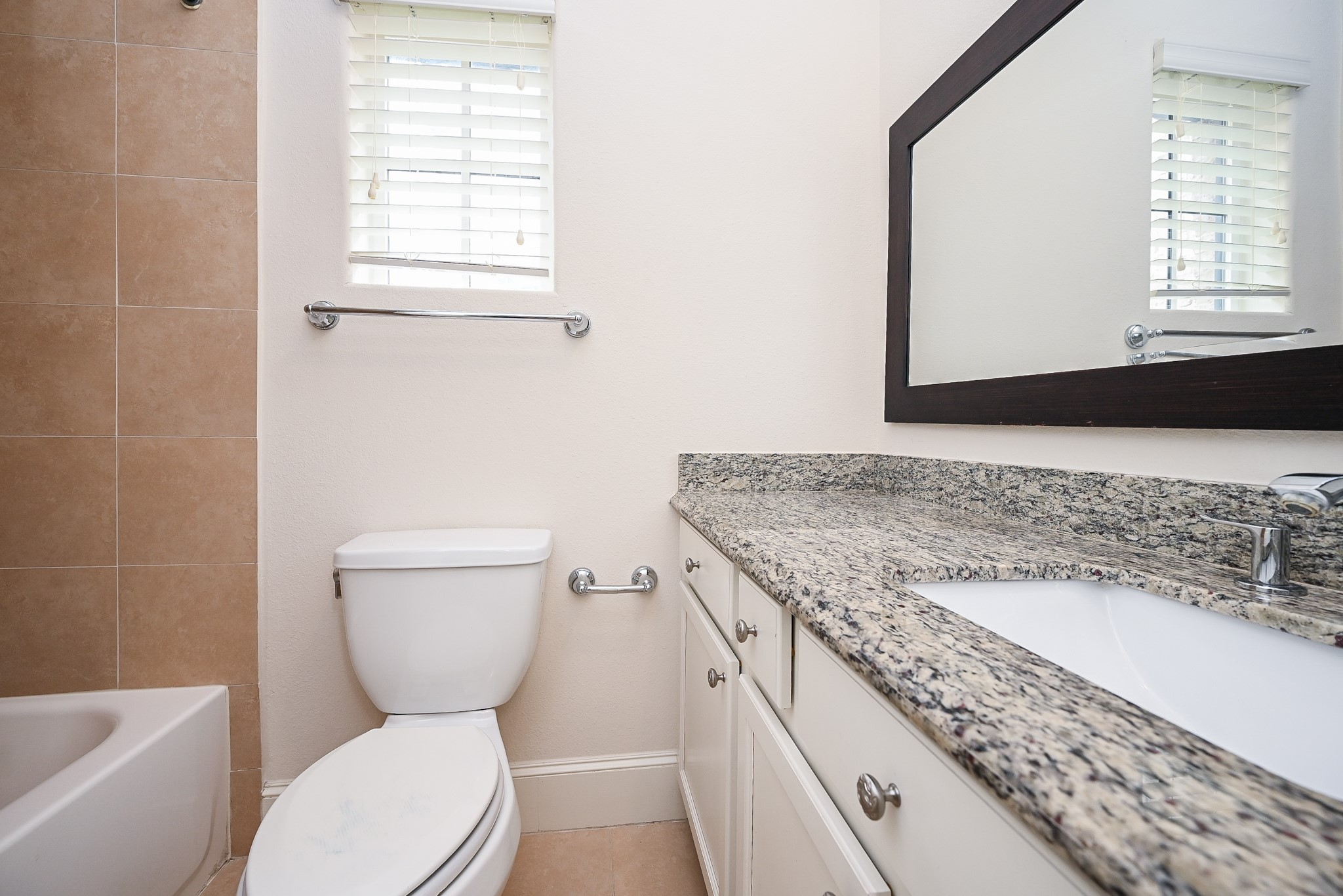 9546 London Bridge Station Houston, TX 77045 - Photo 24 of 41 This bathroom combines natural granite and a tiled shower surround to create a serene and simplified relaxation space.