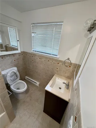 a bathroom with a sink toilet and a window