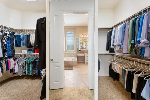 a view of walk in closet with clothes and shoes