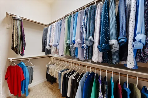 a view of walk in closet with clothes and shoes