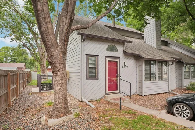 a front view of a house with a tree