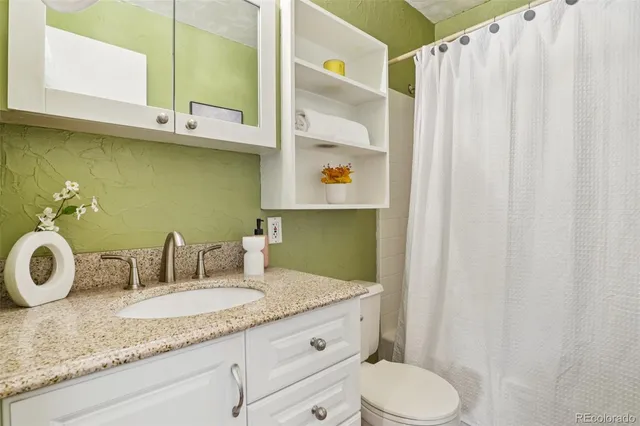 a view of a house with a small yard and wooden fence