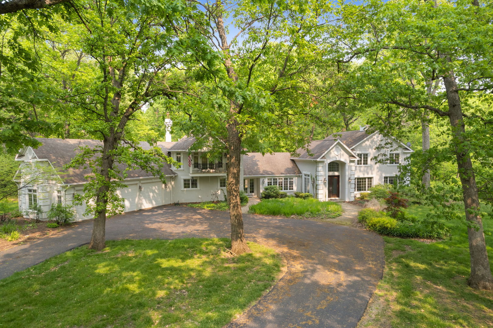 a front view of a house with a yard and trees