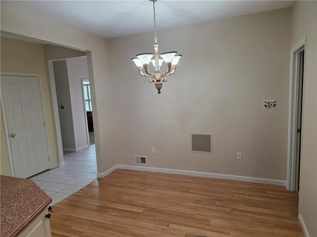 a view of a room with wooden floor and chandelier