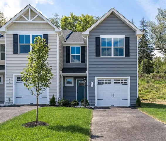 a front view of a house with a yard and garage