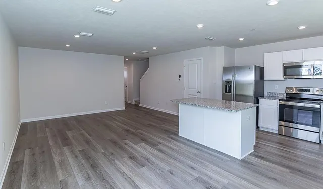 a kitchen with a refrigerator and a stove top oven