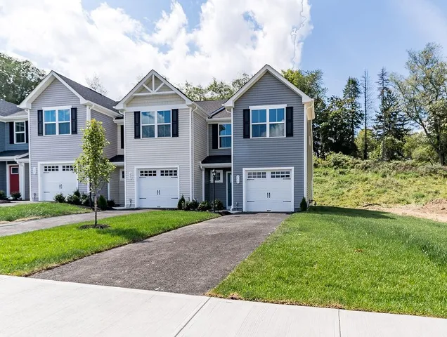 a view of a big house with a big yard and large trees