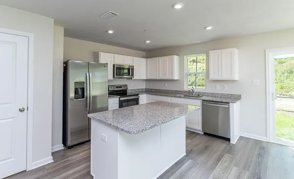 a kitchen with stainless steel appliances granite countertop a refrigerator sink and microwave