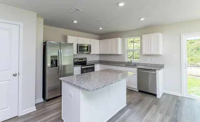 a kitchen with stainless steel appliances granite countertop a refrigerator sink and microwave