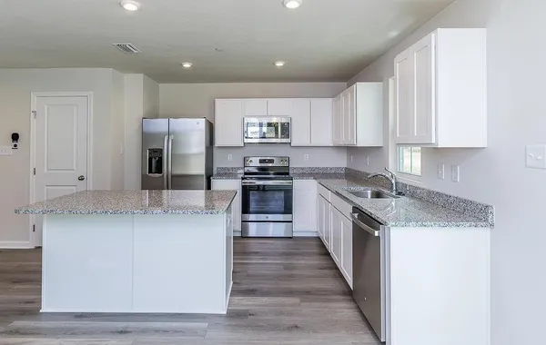 a large kitchen with stainless steel appliances granite countertop a stove and a sink