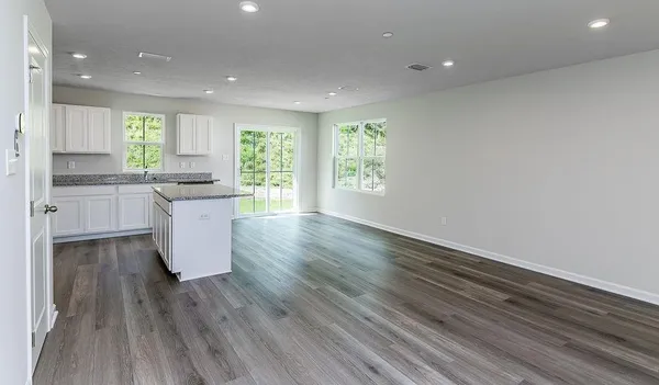 a large kitchen with cabinets wooden floor and stainless steel appliances