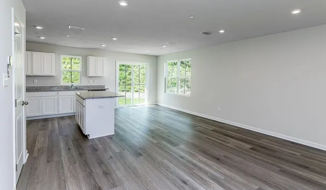 a large kitchen with cabinets wooden floor and stainless steel appliances