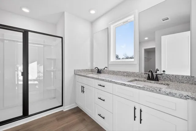 a bathroom with a granite countertop sink toilet and shower