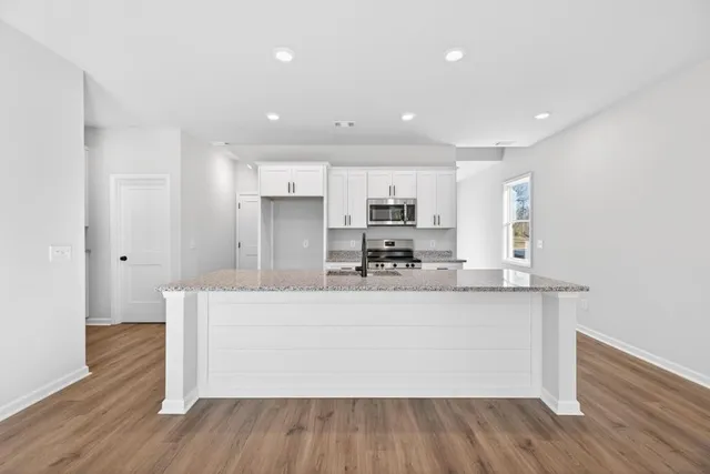 a kitchen with sink a stove and cabinets
