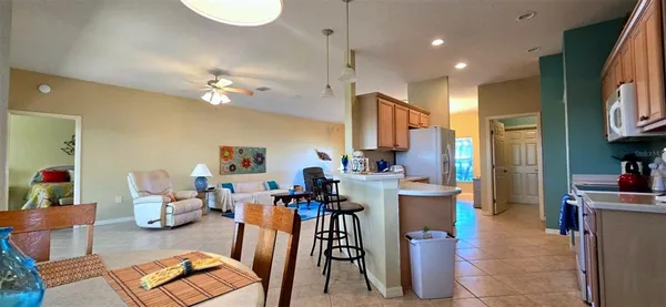 a living room with furniture a flat screen tv and kitchen view