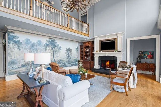 a living room with a large window and chandelier