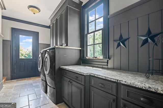 a dining room with wooden floor a chandelier a glass table and chairs