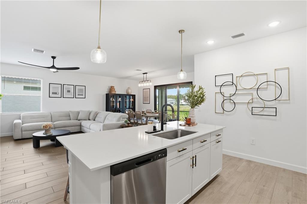 20428 Verawood Loop Estero, FL 33928 - Photo 11 of 50 Kitchen with stainless steel dishwasher, white cabinets, wood finish floors, ceiling fan, and a center island with sink