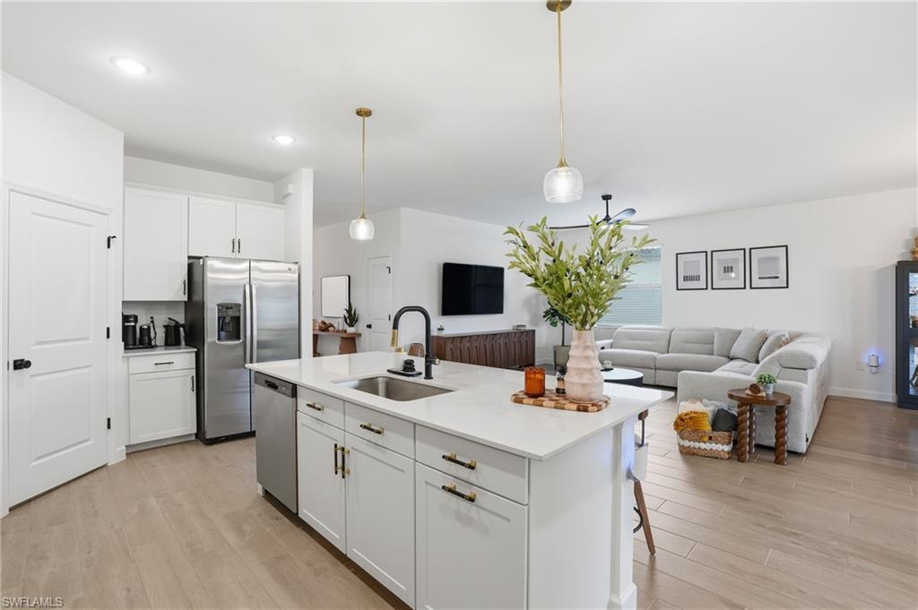 20428 Verawood Loop Estero, FL 33928 - Photo 12 of 50 Kitchen featuring white cabinets, open floor plan, hanging light fixtures, and light wood-style flooring