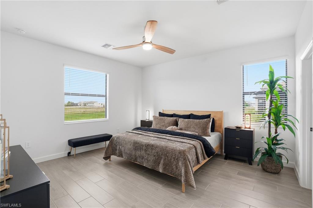 20428 Verawood Loop Estero, FL 33928 - Photo 16 of 50 Bedroom featuring wood finish floors, ceiling fan, and multiple windows