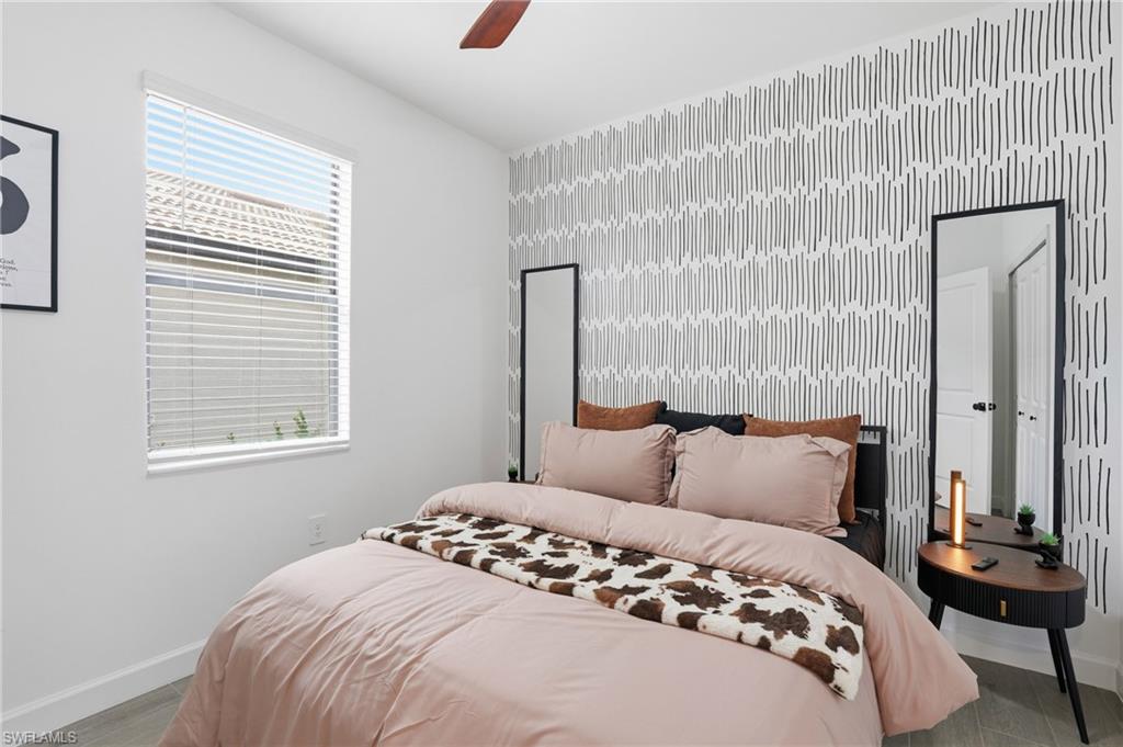 20428 Verawood Loop Estero, FL 33928 - Photo 24 of 50 Bedroom featuring an accent wall, wallpapered walls, wood finished floors, and a ceiling fan